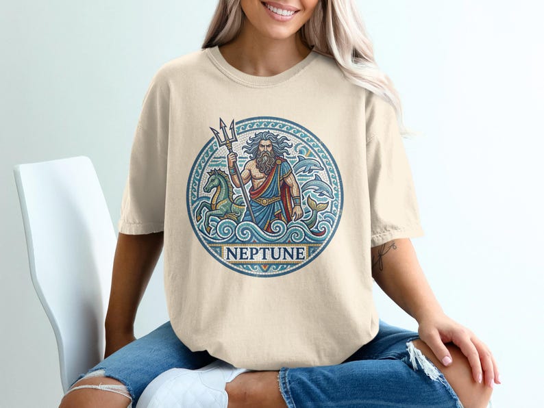 Neptune graphic on tan t-shirt with trident, sea creatures, and waves.