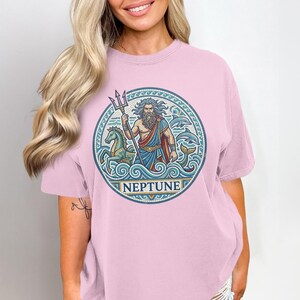 T-shirt featuring a circular graphic of Neptune with trident, horses, and dolphins.