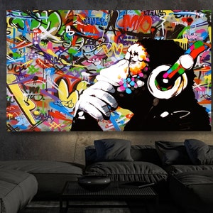 Può includere: Un dipinto astratto colorato di una scimmia con le cuffie. Lo sfondo è pieno di scritte e disegni in stile graffiti.