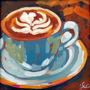 Könnte beinhalten: Eine blaue und weiße Kaffeetasse mit braunem Kaffee und weißem Latte-Art-Design. Die Tasse steht auf einer weißen und orangefarbenen Untertasse.