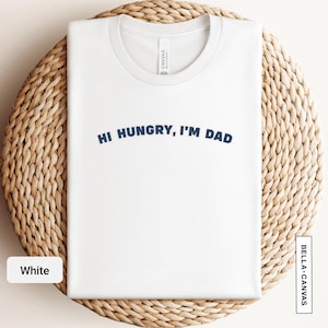Peut inclure: T-shirt blanc avec le texte "Hi Hungry, I'm Dad" imprimé en bleu.