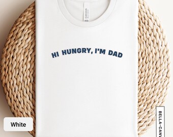 Könnte beinhalten: Weißes T-Shirt mit dem Text "Hi Hungry, I'm Dad" in blau.