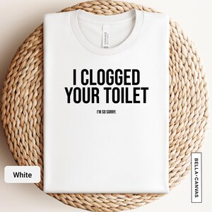 a white t - shirt that says i logged your toilet on it