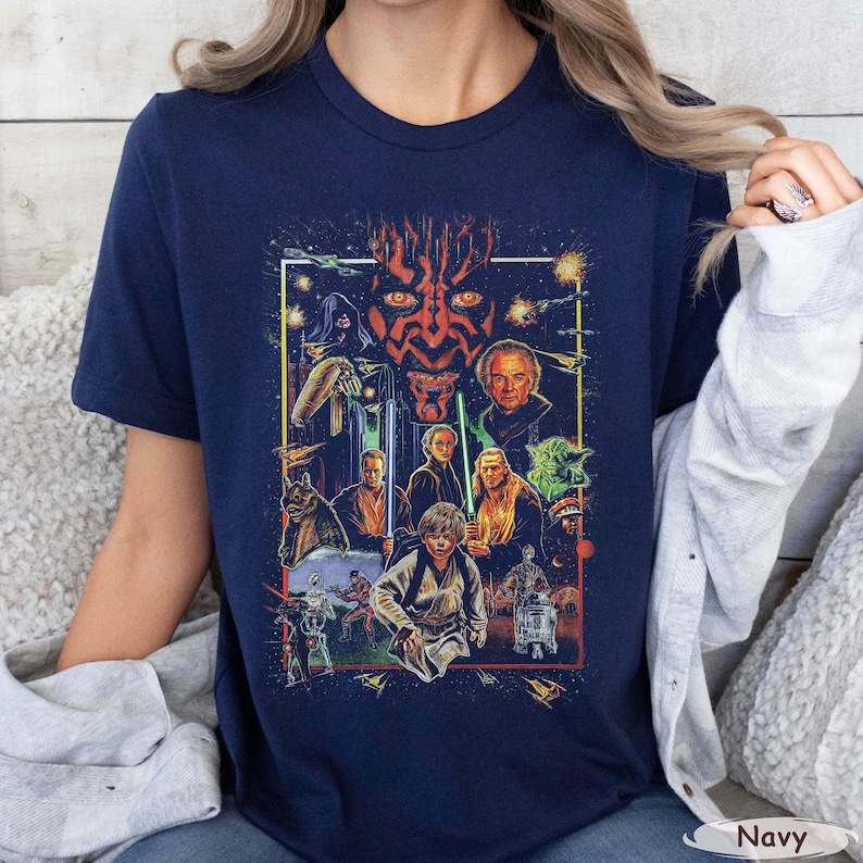 May include: Navy blue t-shirt featuring a colorful graphic of Star Wars characters, including Darth Maul, Yoda, and Luke Skywalker. The design is framed with a white border and includes the word "Navy" at the bottom.