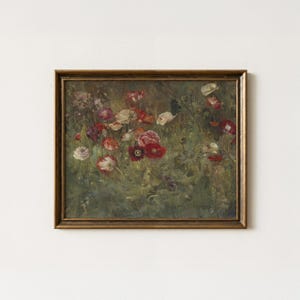 Puede incluir: Un cuadro rectangular enmarcado que representa un campo de flores silvestres en tonos rojos, blancos y morados sobre un fondo verde oscuro. La obra está encerrada en un marco de madera marrón sencillo con veta visible y borde biselado.