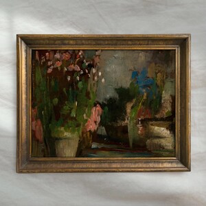 Peut inclure: Peinture &agrave; l'huile dans un cadre dor&eacute; repr&eacute;sentant une sc&egrave;ne de jardin avec des plantes en pot et des fleurs. L'&oelig;uvre pr&eacute;sente des teintes roses, bleues et vertes, avec des coups de pinceau visibles. L'esth&eacute;tique est vintage.