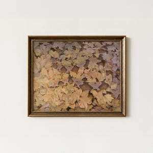 May include: A framed rectangular wall art piece featuring a detailed painting of a copperhead snake camouflaged among a dense layer of fallen autumn leaves in shades of brown, tan, and muted purple, enclosed in a metallic gold-toned frame.