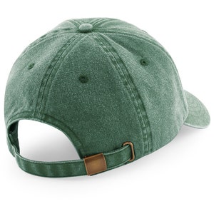 Puede incluir: Una gorra de b&eacute;isbol de algod&oacute;n verde lavado con una correa ajustable marr&oacute;n. La gorra tiene un ajuste cl&aacute;sico y relajado.