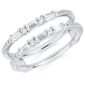 Puede incluir: Dos anillos de plata con un diseño delicado. Cada anillo presenta una fila de pequeños diamantes redondos y una serie de piedras más grandes, de corte rectangular. Los anillos están muy juntos, creando un efecto en capas, sobre un fondo blanco.