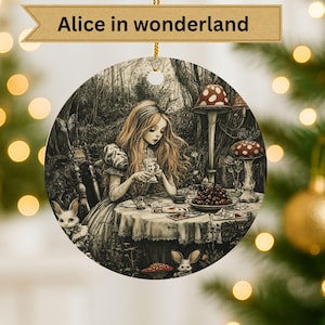 Peut inclure: Ornement rond avec une illustration détaillée d'"Alice au pays des merveilles". L'image représente Alice à une table avec des cartes à jouer, entourée de champignons et de lapins. Le texte "Alice in wonderland" est en haut.