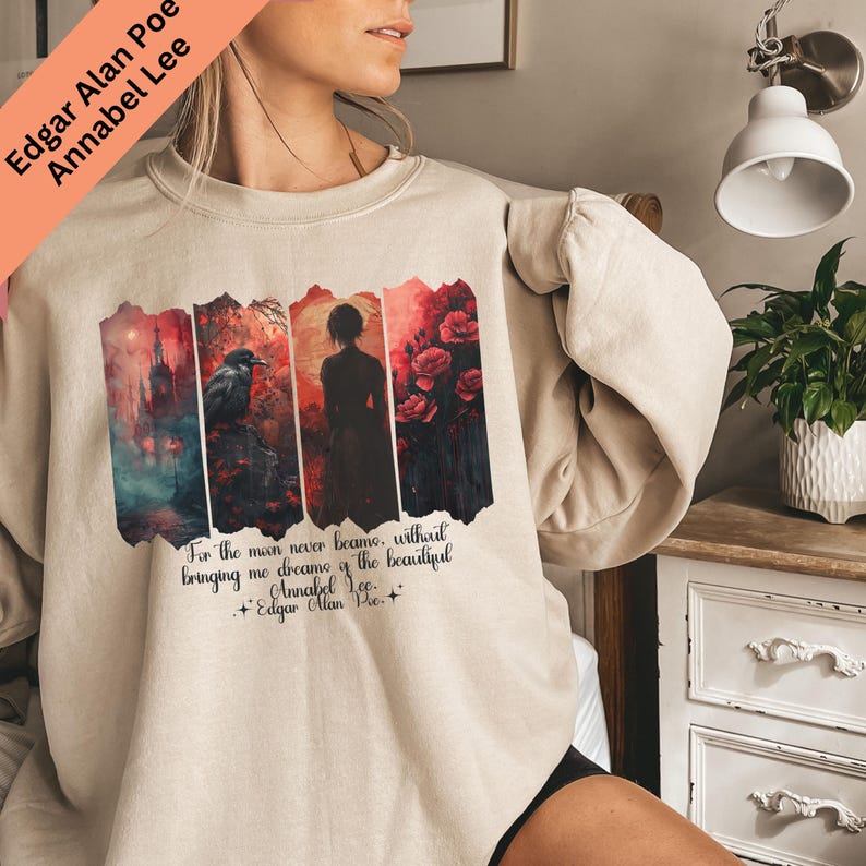 Puede incluir: Sudadera beige con un dise&ntilde;o gr&aacute;fico inspirado en el poema "Annabel Lee" de Edgar Allan Poe. El dise&ntilde;o incluye un cuervo, una silueta y elementos florales. Tambi&eacute;n se incluye el texto "For the man never became, without bringing me dreams of the beautiful".