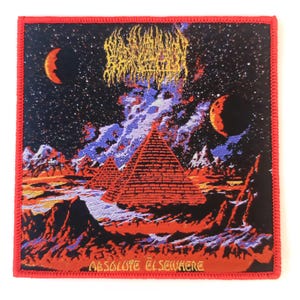 May include: Square patch with a red border. The patch depicts a surreal landscape with pyramids, moons, and a starry sky. The text "ABSOLUTE ELSEWHERE" is at the bottom. A band name is at the top.
