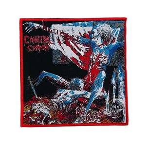 May include: A square fabric patch with a red border featuring the Cannibal Corpse Tomb of the Mutilated album artwork. The graphic depicts a blue-toned figure with white and red details, a skull, and candles against a black background.