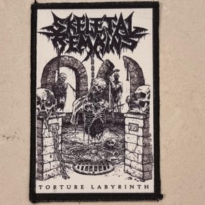 May include: A black and white patch featuring the words "Skeletal Remains" above a detailed illustration of a torture scene. The image includes skeletons, skulls, and a labyrinth design. The text "Torture Labyrinth" is at the bottom.