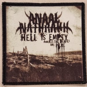 May include: Square patch with a black border featuring the band name "Anaal Nathrakh" in a gothic font. The text "Hell is Empty and All the Devils are Here" is also displayed. The background shows a sepia-toned landscape with a ruined building.