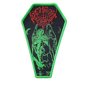 Può includere: Toppa nera a forma di bara con bordo verde. La toppa presenta una grafica rossa e verde di una figura cornuta, un angelo e la parola "ASGARD" in rosso. Due lune crescenti sono su entrambi i lati dell'angelo.