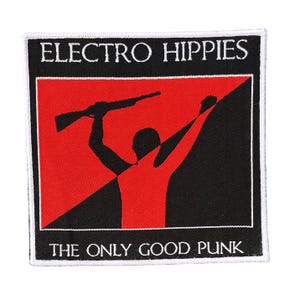 Op de afbeelding: Vierkante patch met de tekst "ELECTRO HIPPIES" boven een rood-zwarte afbeelding van een persoon die een geweer vasthoudt. De tekst "THE ONLY GOOD PUNK" staat onder de afbeelding. De patch heeft een witte rand.
