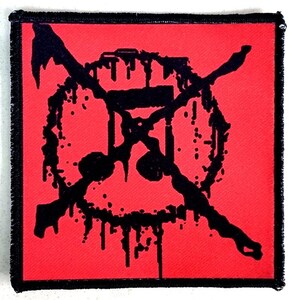 Puede incluir: Parche cuadrado con fondo rojo y diseño negro. El diseño presenta un círculo con una línea que lo atraviesa, cruzado por dos líneas diagonales. El diseño tiene un efecto de goteo, con gotas y salpicaduras negras.