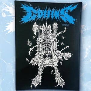 May include: A rectangular black fabric patch featuring a bright blue jagged logo at the top that reads COFFINS. Below the text is a white graphic illustration of a skeletal figure holding an axe and a chainsaw, surrounded by small floating debris.