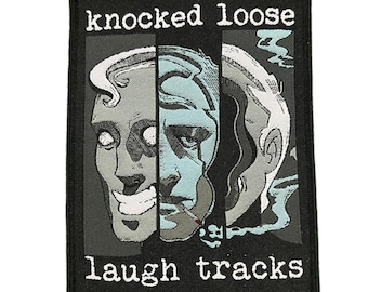 May include: Black rectangular patch with the words "knocked loose" and "laugh tracks" in white. The patch features a graphic of a face split into three sections, with blue and gray tones.