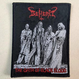 Puede incluir: Parche bordado en blanco y negro con el nombre de la banda "Behemoth" en letras rojas y el texto "The Oath of Black Blood" en letras rojas. El parche presenta un fondo negro con cinco figuras en túnicas blancas.