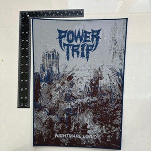 May include: A rectangular patch featuring the band name "POWER TRIP" in a blue, stylized font. The patch has a dark illustration below the text, with the words "NIGHTMARE LOGIC" at the bottom. It has a dark blue border.