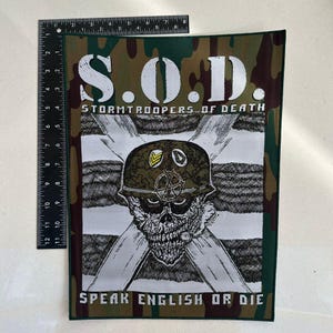 May include: A rectangular patch with a camouflage border and the text "S.O.D. STORMTROOPERS OF DEATH" in white. Below is a skull wearing a military helmet, with the text "SPEAK ENGLISH OR DIE".