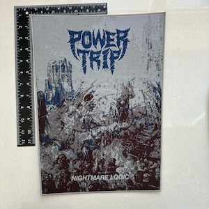 May include: A rectangular patch featuring the text "POWER TRIP" in blue, stylized lettering. The background is a distressed gray with a dark, detailed illustration. The text "NIGHTMARE LOGIC" is at the bottom.