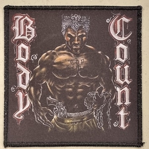 May include: Square patch with a black border featuring a muscular figure wearing a bandana, holding a gun and chains. The words "Body Count" are written vertically on the sides in a gothic font. The figure has a tattoo that says "Cop".