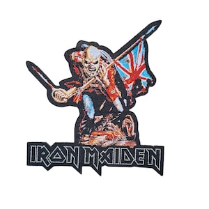 Puede incluir: Parche bordado con una figura esquelética sosteniendo una espada y una bandera de la Union Jack. La figura es en tonos rojos, negros y blancos. Las palabras "IRON MAIDEN" están bordadas en letras blancas debajo.