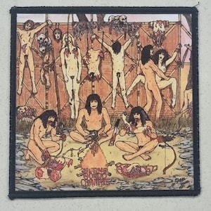 Puede incluir: Parche cuadrado con una ilustración gráfica que representa una escena caníbal. La obra presenta figuras desnudas, partes del cuerpo colgadas y una hoguera central. El texto "ULTRA CONDO CANNIBAL" es visible en la parte inferior.