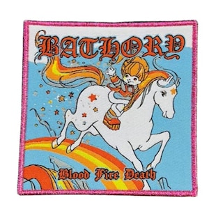 Könnte beinhalten: Quadratischer Aufnäher mit einer Cartoon-Illustration eines Kindes, das auf einem weißen Pferd über einem Regenbogen reitet. Der Aufnäher trägt oben den Text "BATHORD" und unten "Blood Fire Death". Der Rand ist rosa.