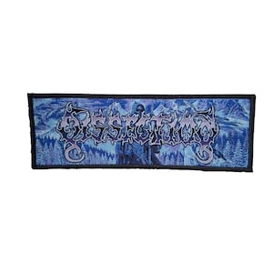 May include: A rectangular patch with a black border. The patch features a blue and purple design with the word "Dissimulation" in a stylized font. The background depicts a snowy mountain scene with a figure.