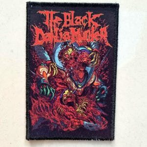 Könnte beinhalten: Ein rechteckiger Aufnäher mit dem Text "The Black Dahlia Murder" in roter, stilisierter Schrift. Der Aufnäher zeigt eine detaillierte, farbenfrohe Illustration einer grotesken Figur mit mehreren Köpfen und Gliedmaßen in Rot-, Orange-, Grün- und Blautönen.