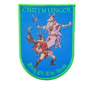 May include: A blue patch with a green border featuring a fantasy illustration. The image depicts two figures, one in red and the other in white, with the text "CIRITH UNGOL" and "King Of The Dead" in green.