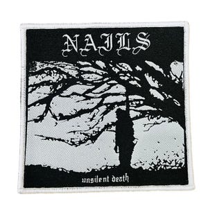 Puede incluir: Parche cuadrado en blanco y negro con la palabra "NAILS" en fuente gótica. El parche presenta una figura silueteada bajo un árbol con las palabras "unsilent death" en la parte inferior. El parche tiene un borde blanco.