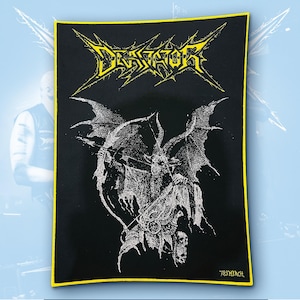 May include: A rectangular black fabric patch with a yellow border. The top features the yellow text "DEVIATOR" in a jagged font. Below, a white graphic depicts a winged, horned creature holding a bow and arrow, with "783 MERCH" in the corner.