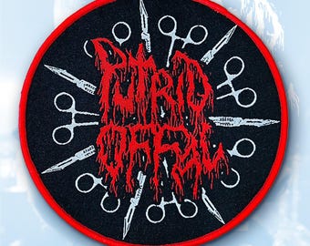 May include: A round black patch with a red border. The patch features the text "PUTRID OFFAL" in a dripping red font, surrounded by white surgical scissors and scalpels. The design has a horror theme.