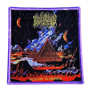May include: Square patch with a purple border. The design features pyramids, crescent moons, and the text "ABSOLUTE ELSEWHERE" against a night sky. The artwork includes a starry sky, blue and orange clouds, and a stylized font.