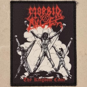 May include: Black patch with red text and a graphic of three figures on crosses. The text at the top reads "MORBID ANGEL" and the text at the bottom reads "Thy Kingdom Come". The figures are white and the background is black.
