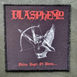 Può includere: Toppa quadrata nera con la scritta "BLASPHEME" in rosso, con caratteri gotici. Un'illustrazione bianca di una figura alata con arco e freccia è centrata sotto il testo. Il testo "Fallen Angel Of Doom...." è sotto.