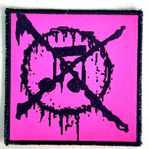 Könnte beinhalten: Quadratischer Aufnäher mit einem pinkfarbenen Hintergrund und einem schwarzen, abstrakten Design. Das Design scheint eine stilisierte Sanduhrform zu sein, die von zwei Linien gekreuzt wird. Der Aufnäher hat einen schwarzen Rand.