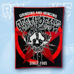 May include: A rectangular black fabric patch with a red border featuring a white graphic of a skull wearing headphones. The text reads GRINDING AND MINCING, AGATHOCLES, and SINCE 1985. A large red star is centred behind the skull design on the black background.