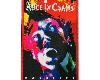 May include: A rectangular patch with a red border and background. The patch features the band name "Alice in Chains" in white, above a colorful illustration of a screaming face. The word "FACELIFT" is printed at the bottom.