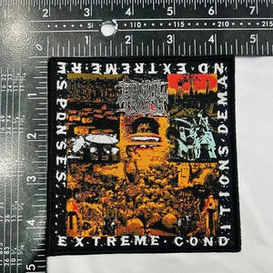 Op de afbeelding: Een zwarte vierkante patch met de woorden "NO EXTREME CONDITIONS DEMAND SPONSES" en "EXTREME COND" in het wit. De patch heeft een collage van afbeeldingen in oranje, bruin en groen.