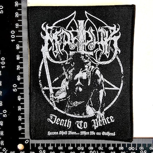 May include: Black rectangular patch featuring a white graphic of a horned figure within a pentagram, holding a sword. The text "Death To Peace" and "Heaven Shall Burn... When We are Gathered" are below. The patch measures approximately 10 cm by 7.5 cm.