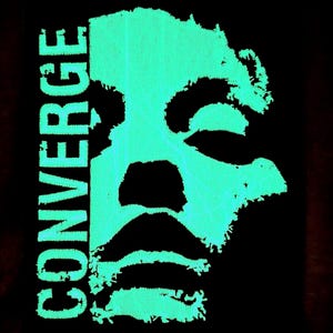 May include: A black graphic design with a teal-coloured, stylized face. The word "CONVERGE" is stacked vertically on the left in the same teal shade. The design has a textured, digital appearance, with a striking contrast between the colours.