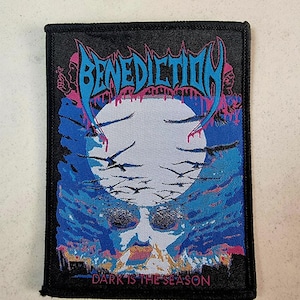 Op de afbeelding: Zwarte en blauwe geborduurde patch met de bandnaam "Benediction" in roze en blauwe letters. De patch heeft een witte maan op een blauwe en zwarte achtergrond en de tekst "Dark is the Season" in roze letters.