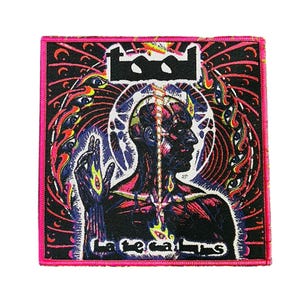 May include: A square patch with a black background and a pink border. The patch features a stylized illustration of a human figure with a glowing spine and the band's logo "Tool". The text "Late caulis" is at the bottom.