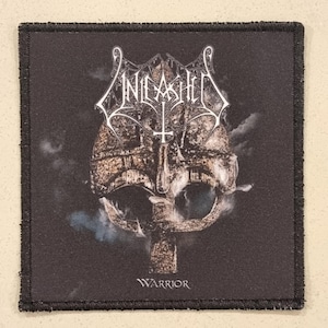 Könnte beinhalten: Quadratischer schwarzer Aufnäher mit dem Wort "UNLEASHED" in Weiß über einer detaillierten Illustration eines Kriegerhelms. Das Wort "Warrior" ist unten in Weiß gedruckt.